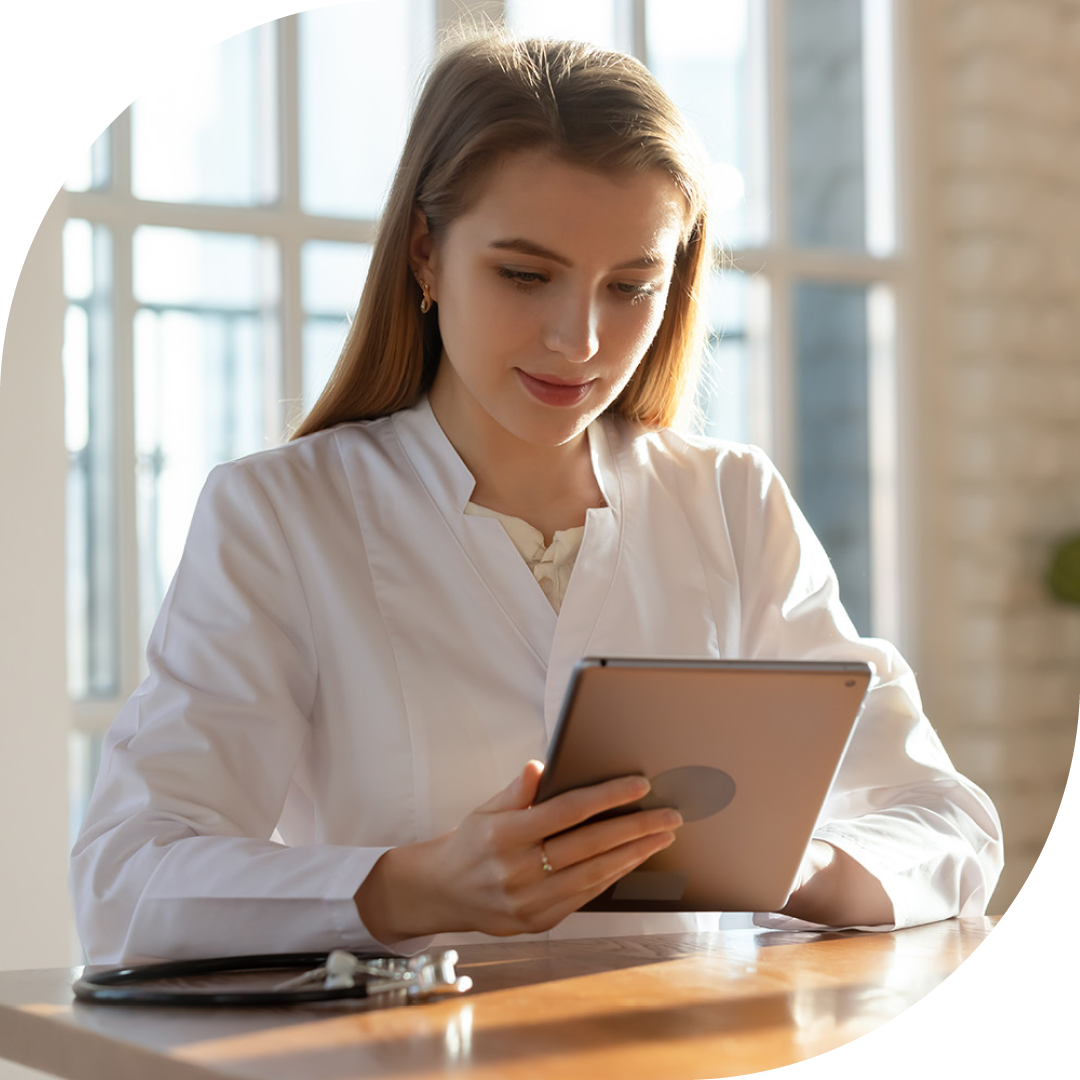 Image of a doctor sat at a desk working on a tablet